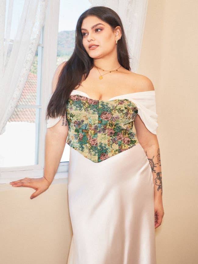 A model posing in the floral top with a white skirt