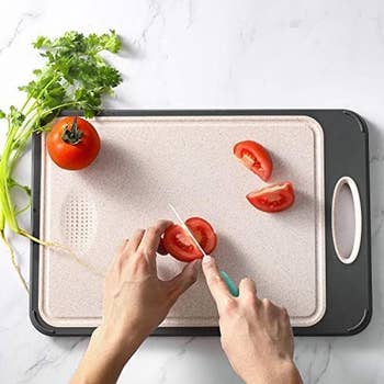 Hands slicing a herb  connected  a cutting committee  with a knife, alongside caller  cilantro and different  full   tomato, promoting room  accessories