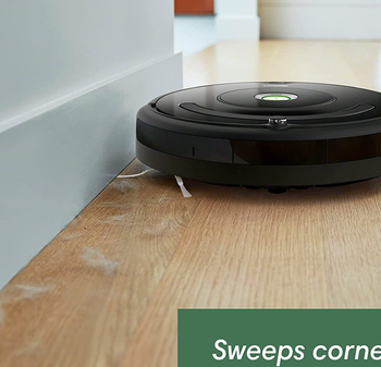 the roomba sweeping up dust bunnies from a wooden floor
