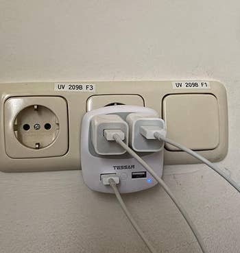 reviewer image of the adapter with iPhone charging ports plugged into it