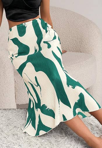 model wearing a trendy green and white patterned midi skirt
