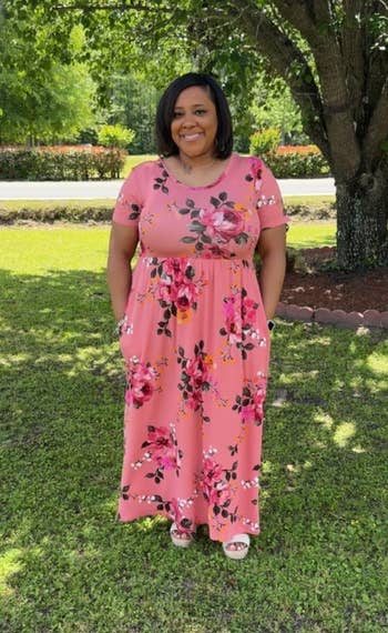 Person successful a floral maxi formal stands connected writer successful a garden, smiling