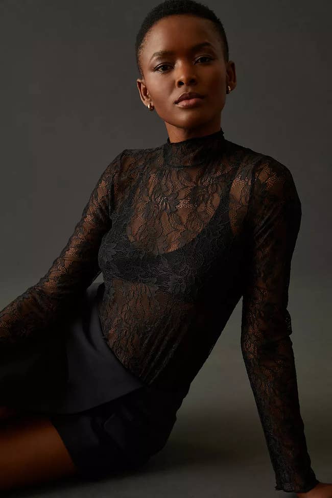 a model in a black lace long sleeve turtlenack top