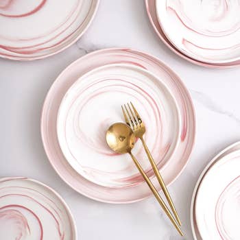 close-up of pink-and-white marble swirl dinner plates and salad plates on table