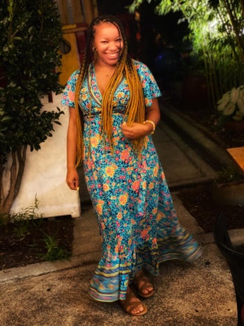 reviewer wearing the floral dress in a blue-green pattern