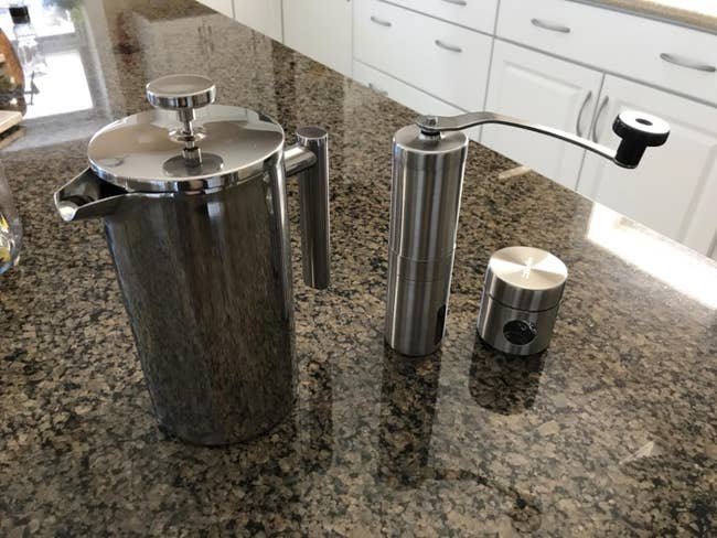 a french press, coffee grinder, and coffee storage