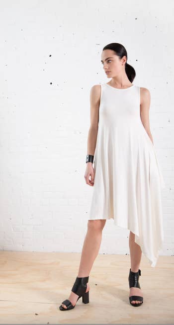 model wearing white tunic dress and black heeled sandals