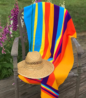 Reviewer image of colorful towel on a chair with straw hat