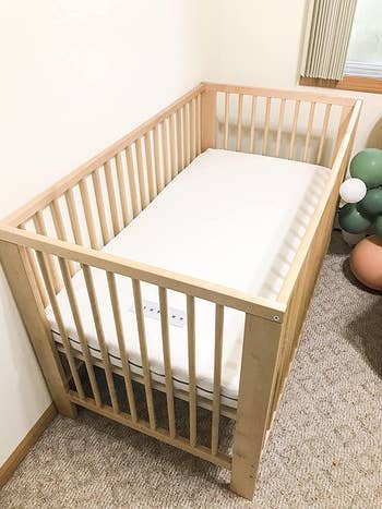 Reviewer's mattress is shown in a crib
