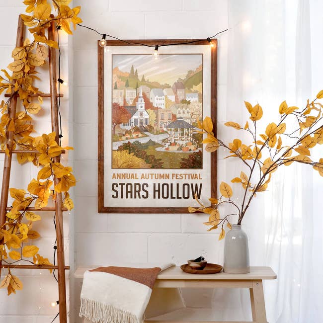 Poster for the Annual Autumn Festival successful Stars Hollow, featuring an illustrated municipality country with autumn decor surrounding it connected a wall