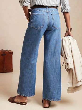 back of a model wearing wide leg blue jeans
