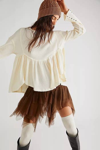 model wearing the cream top with a brown skirt and boots