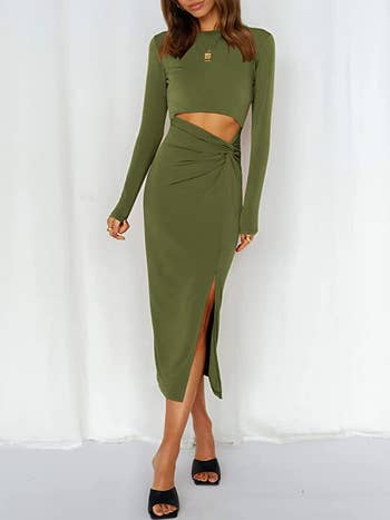 Model in a green long sleeved midi dress with a slit up the side and a high waist twist cut out 