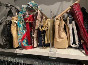 reviewer using dividers to organize handbags in closet