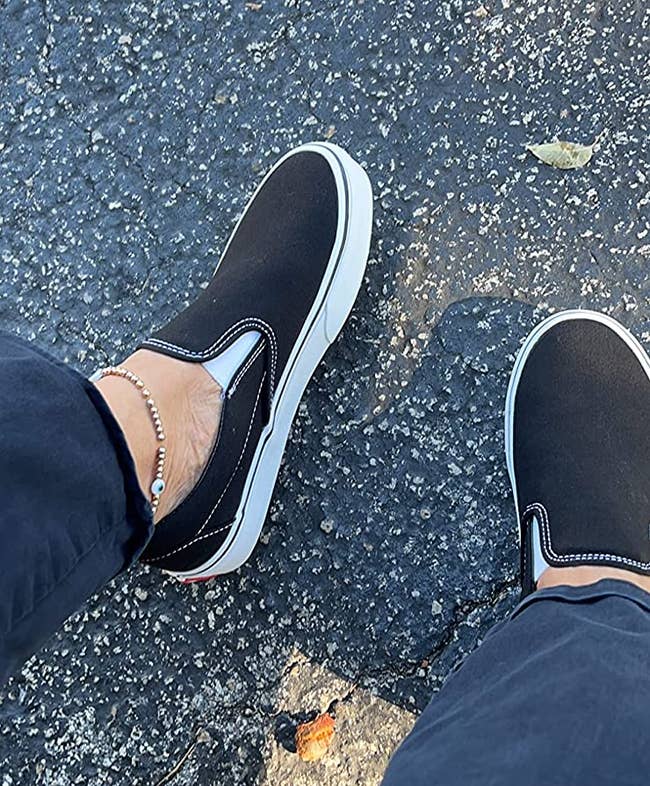 Reviewer wearing black slip on Vans sneakers