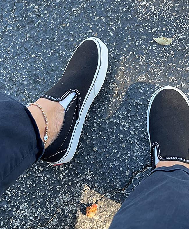 Reviewer wearing black slip on Vans sneakers