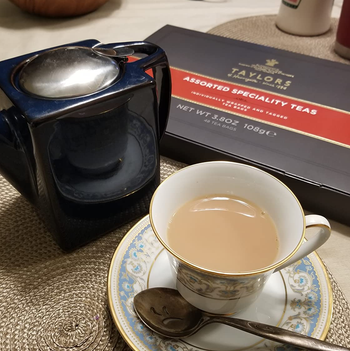 reviewer photo of a cup of tea in front of the assorted tea box