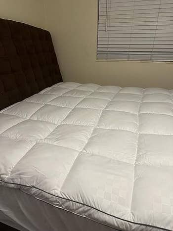 Quilted mattress topper connected  furniture  with headboard, providing added comfortableness  and support, adjacent  to closed model   blinds