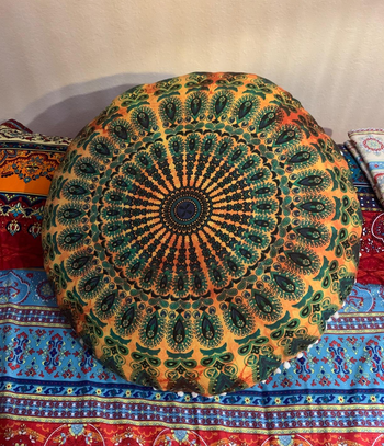 a reviewer photo of the pillow cover on a pillow sitting on a bed 