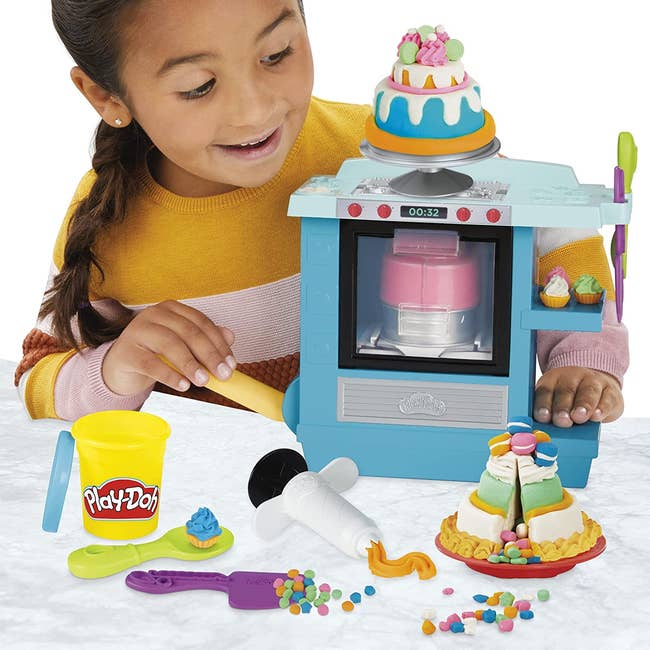 Child model playing with Play-Doh bakery set