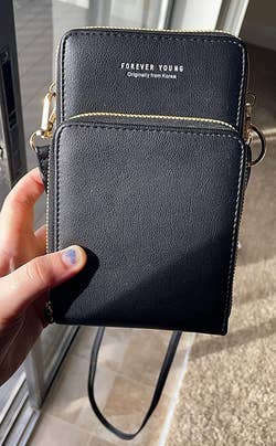 different reviewer holding up the black crossbody phone bag