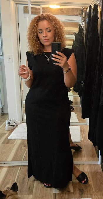 Person successful  a sleeveless achromatic  formal  taking a reflector  selfie successful  a covering  store. Mirror reflection   shows akin  outfits. Casual buying  scene