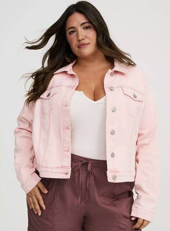 A idiosyncratic wearing a stylish denim overgarment implicit a achromatic apical and casual pants, suitable for a manner diagnostic successful a buying article