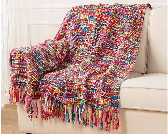 the rainbow blanket draped over a couch 