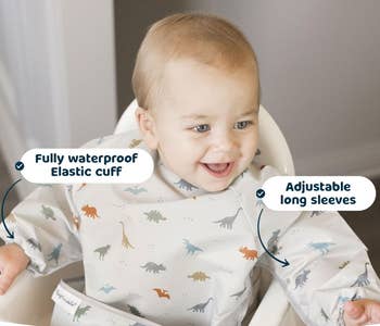 Baby wearing a bib with dinosaur print and long sleeves, text highlights features like waterproof and adjustable cuffs