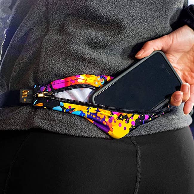 person putting their phone in a spi belt