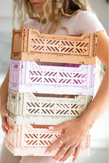Person holding 4 stackable retention crates