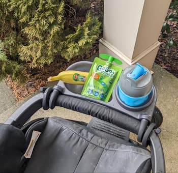 reviewer's stroller tray with a banana and GoGo squeeZ applesauce pouch 