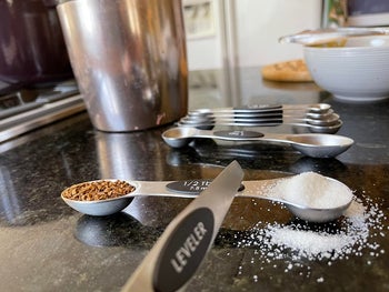 A reviewer's measuring spoon sitting sturdy on the counter with spices in it