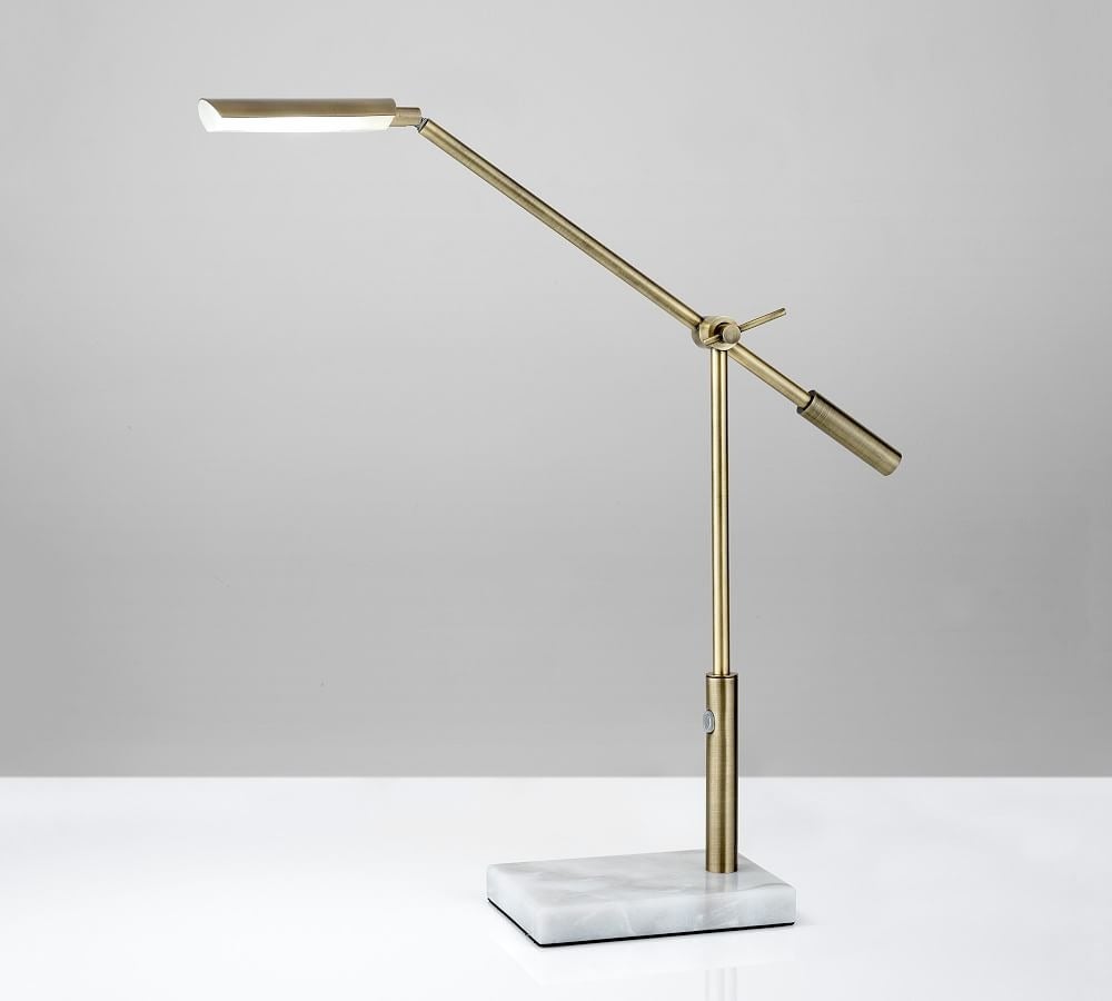 a long thin gold lamp with a rectangular marble base