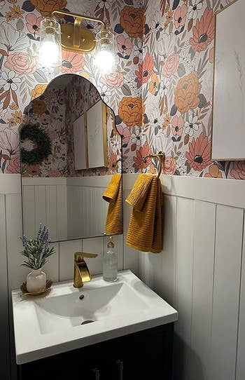 A reviewer uses the white floral wallpaper in their bathroom