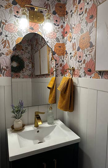 A reviewer uses the white floral wallpaper in their bathroom