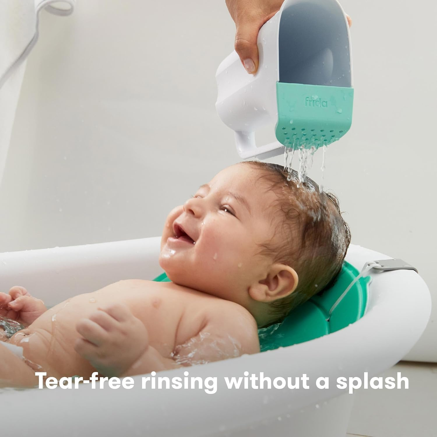 hand pouring water from rinse cup on baby’s hair