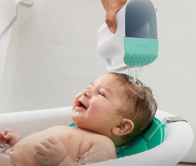 hand pouring h2o from rinse cupful connected baby's hair
