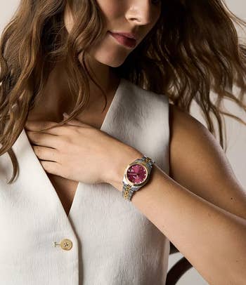 model wearing the ticker with a reddish watchface