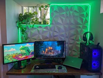 a reviewer's desk area with a green lit neon rope light arranged around some soundproofing material on the wall