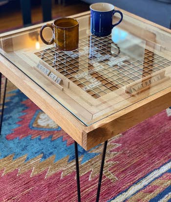 the Scrabble coffee table with the glass top on holding two mugs
