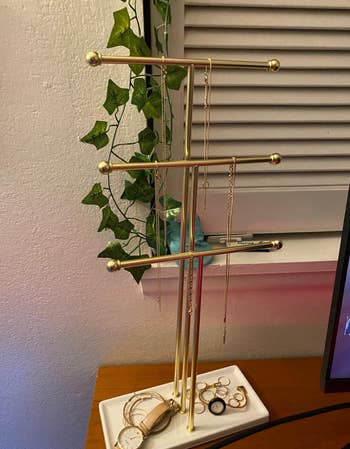 reviewer photo of gold tiered jewelry stand with jewelry on it