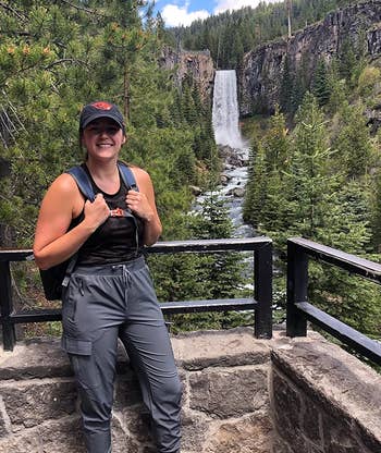 reviewer wearing the gray joggers while hiking near a waterfall