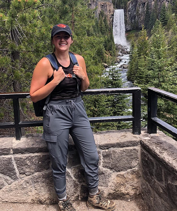 reviewer wearing the gray joggers while hiking near a waterfall