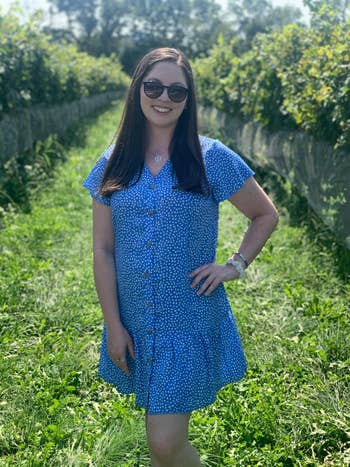 Reviewer successful a short-sleeve, button-down formal with a floral signifier stands successful a vineyard, wearing sunglasses and smiling