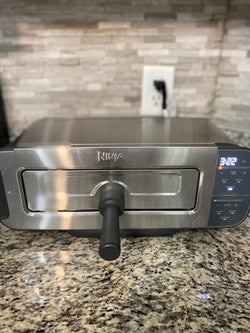 reviewer's toaster on it's side demonstrating how it's also a toaster oven