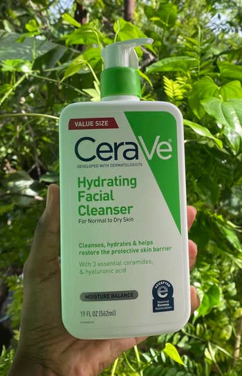 A reviewer holding the CeraVe hydrating facial cleanser