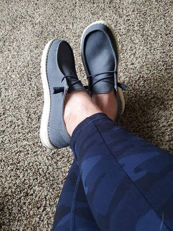 reviewer wearing the navy blue slip ons