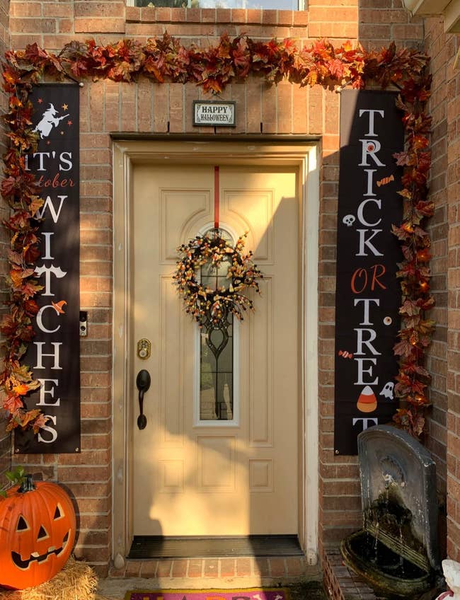 a front door decorated for halloween with the banners on each side of it saying 