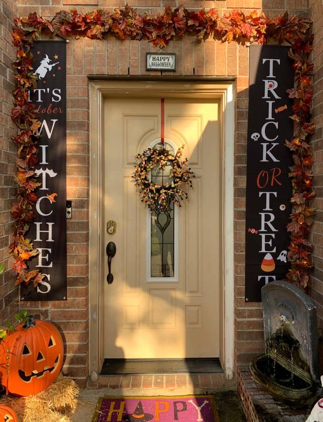 a front door decorated for halloween with the banners on each side of it saying 
